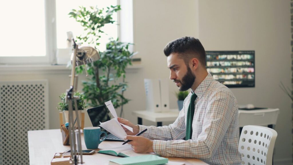 Man at a desk reviewing papers after an Australian visa refused decision